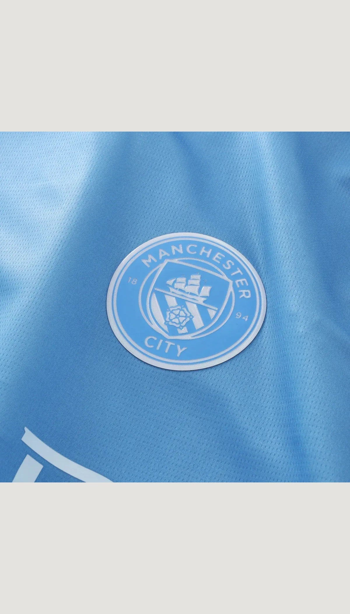 Manchester City local 2026/27 versión jugador — detalle del escudo