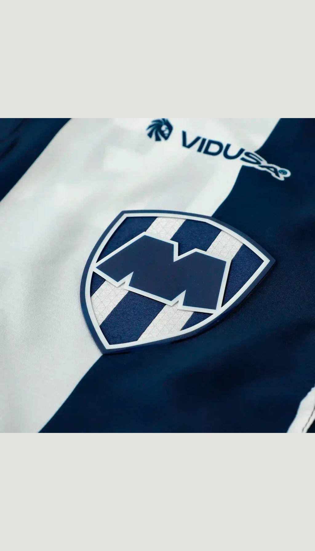 Monterrey local 2026/27 versión jugador — detalle del escudo y tejido