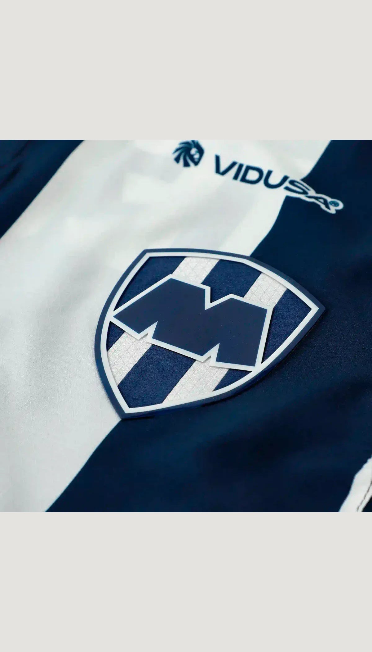 Monterrey local 2026/27 versión jugador — detalle del escudo y tejido