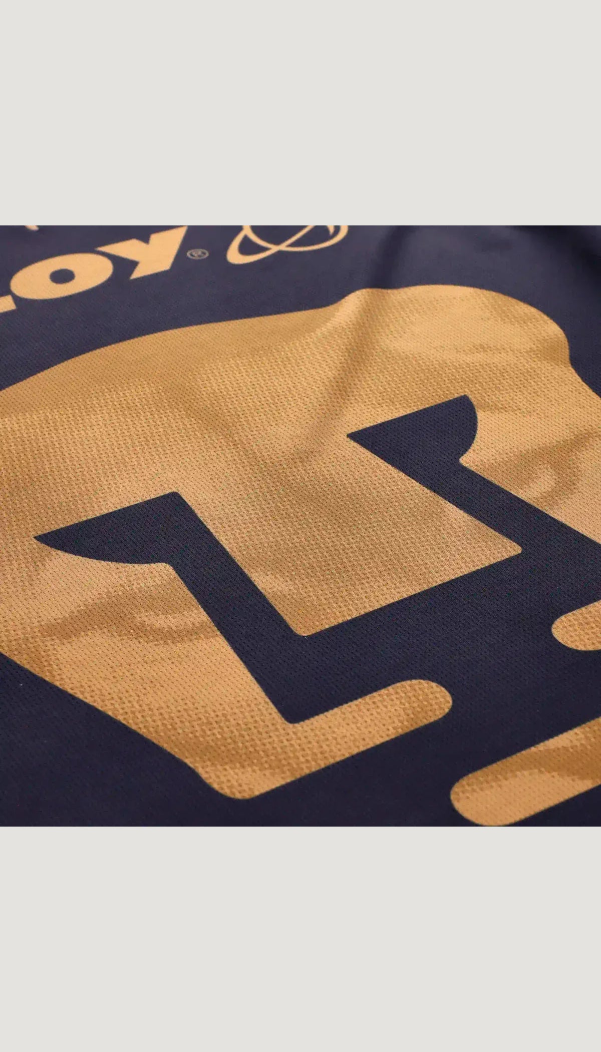 Pumas UNAM local 2026/27 versión jugador no oficial — detalle del tejido y emblema central
